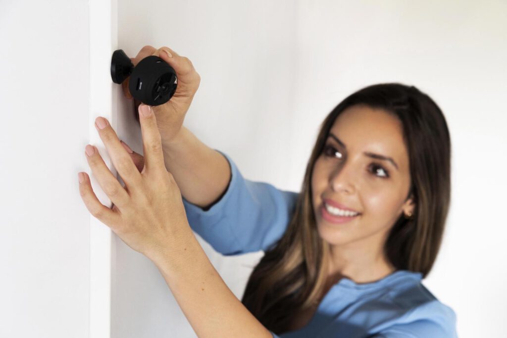 Mujer feliz con su nueva cámara de seguridad con wifi para el hogar